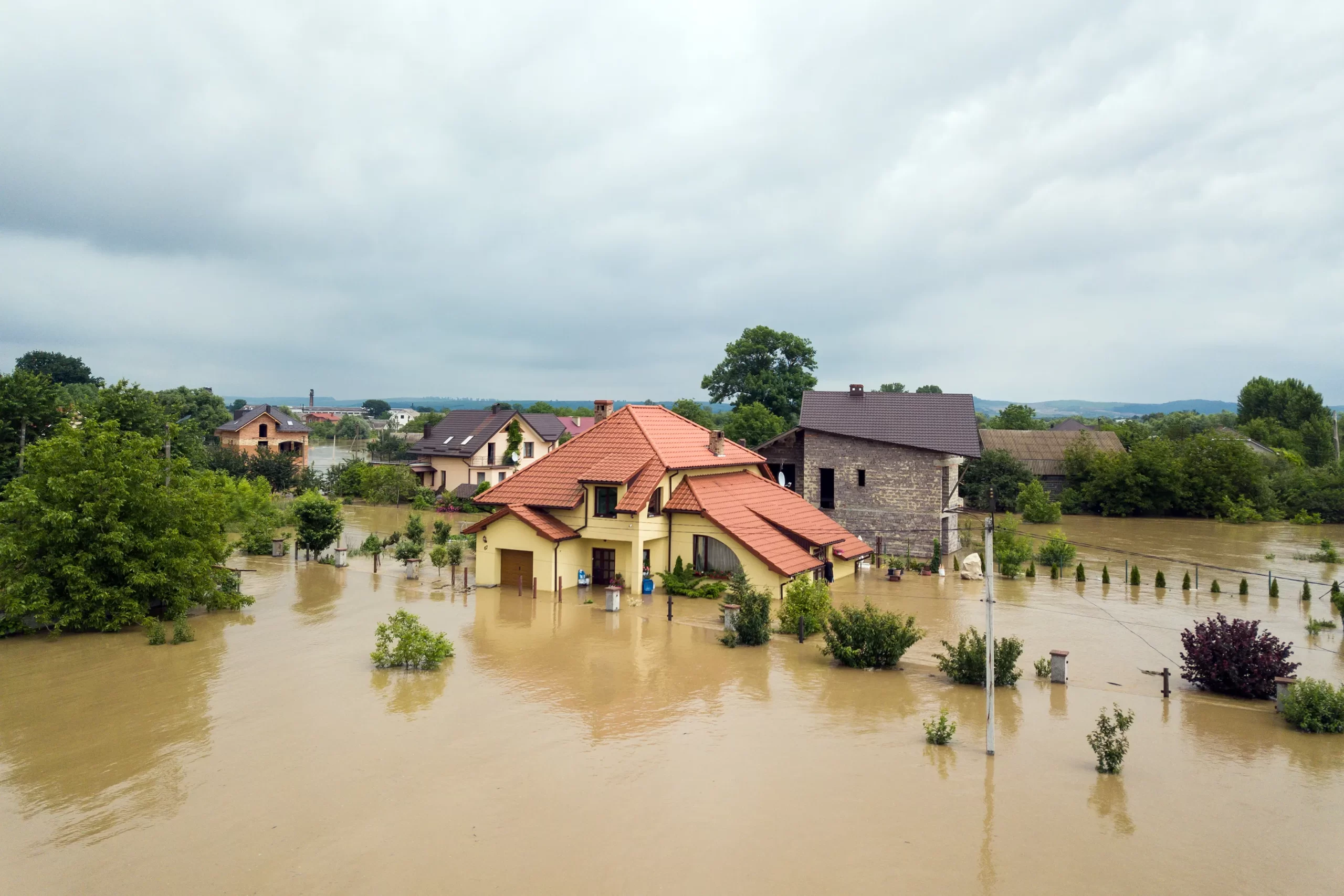 Aerial view of flooded houses with dirty water.