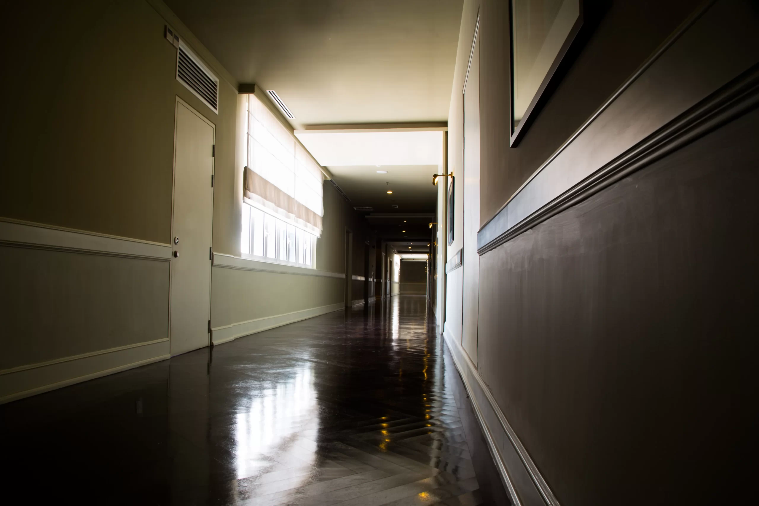 Dark and empty corridor with available natural lighting.