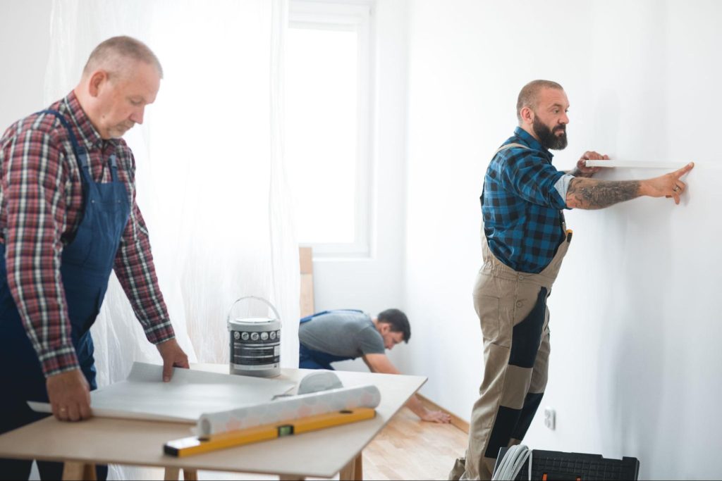 Crew of male workers doing a restoration of a home.