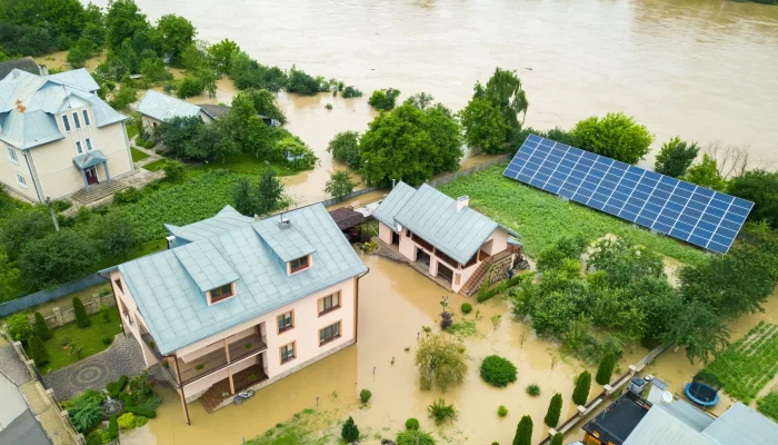 Aerial view of flooded houses with dirty water around them.